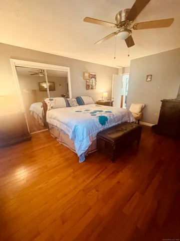 a bedroom with a bed and wooden floor