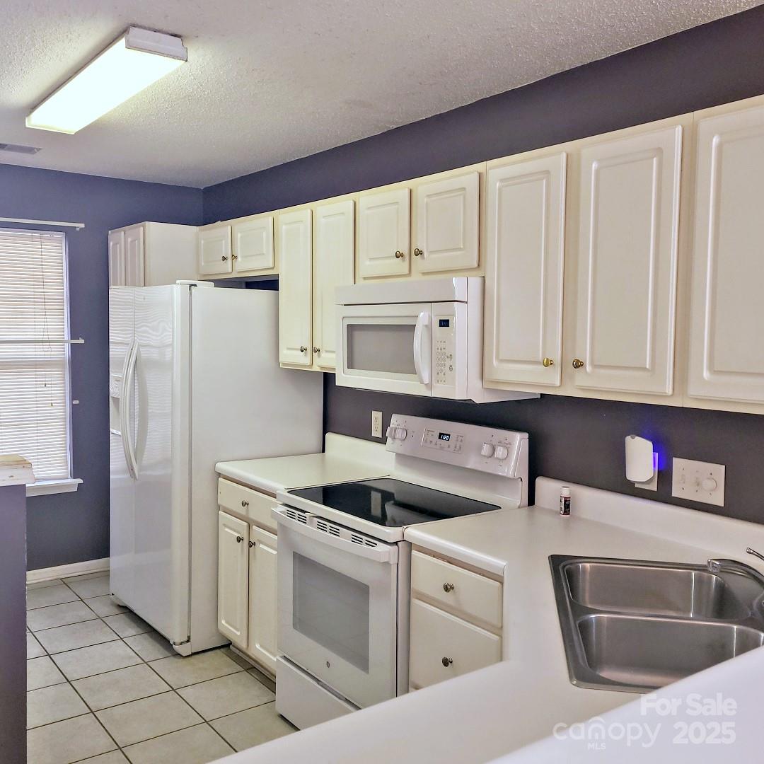 16740 Timber Crossing Road Charlotte, NC 28213 - Photo 2 of 7 a kitchen with white cabinets and refrigerator
