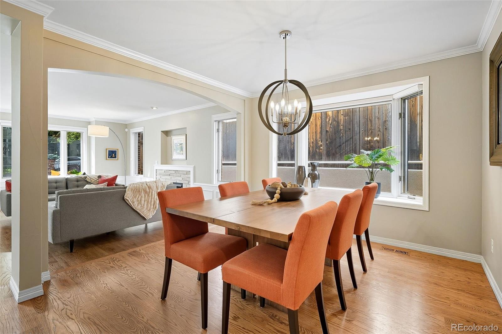 358 Steele Street Denver, CO 80206 - Photo 16 of 48 a view of a dining room with furniture a chandelier and wooden floor