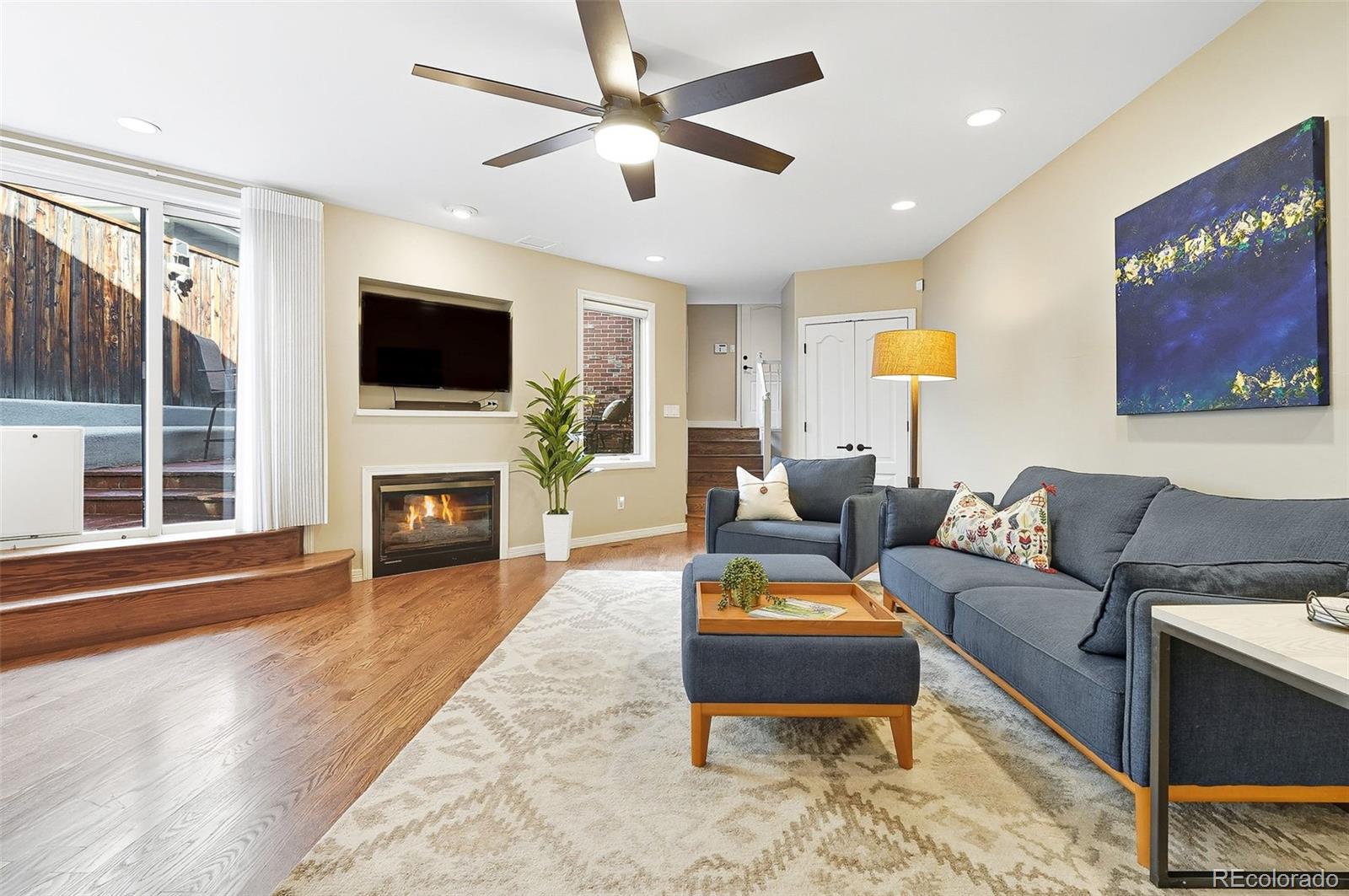 358 Steele Street Denver, CO 80206 - Photo 20 of 48 a living room with furniture a fireplace and a flat screen tv