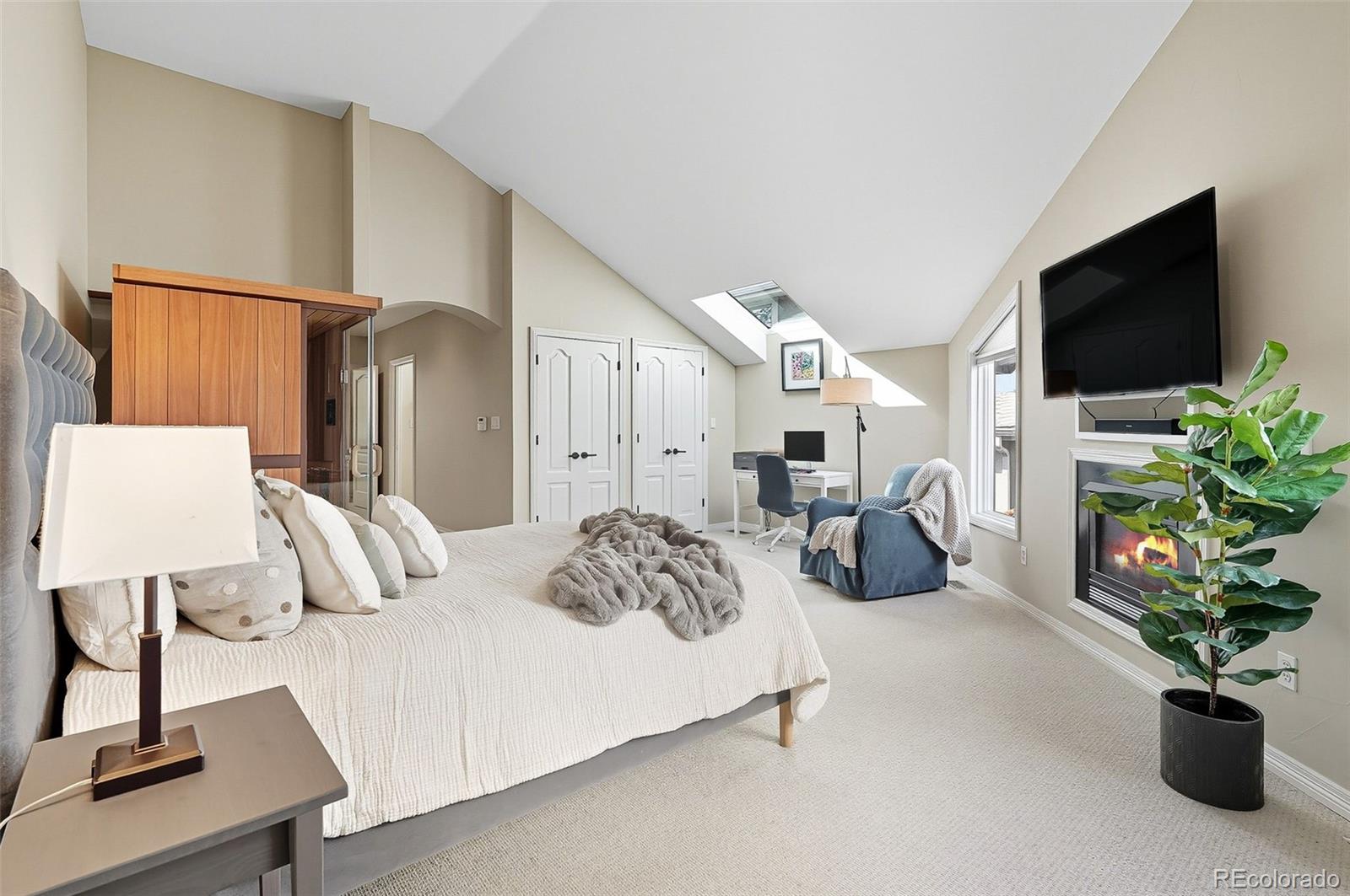 358 Steele Street Denver, CO 80206 - Photo 25 of 48 a bedroom with bed a flat screen tv and a couch