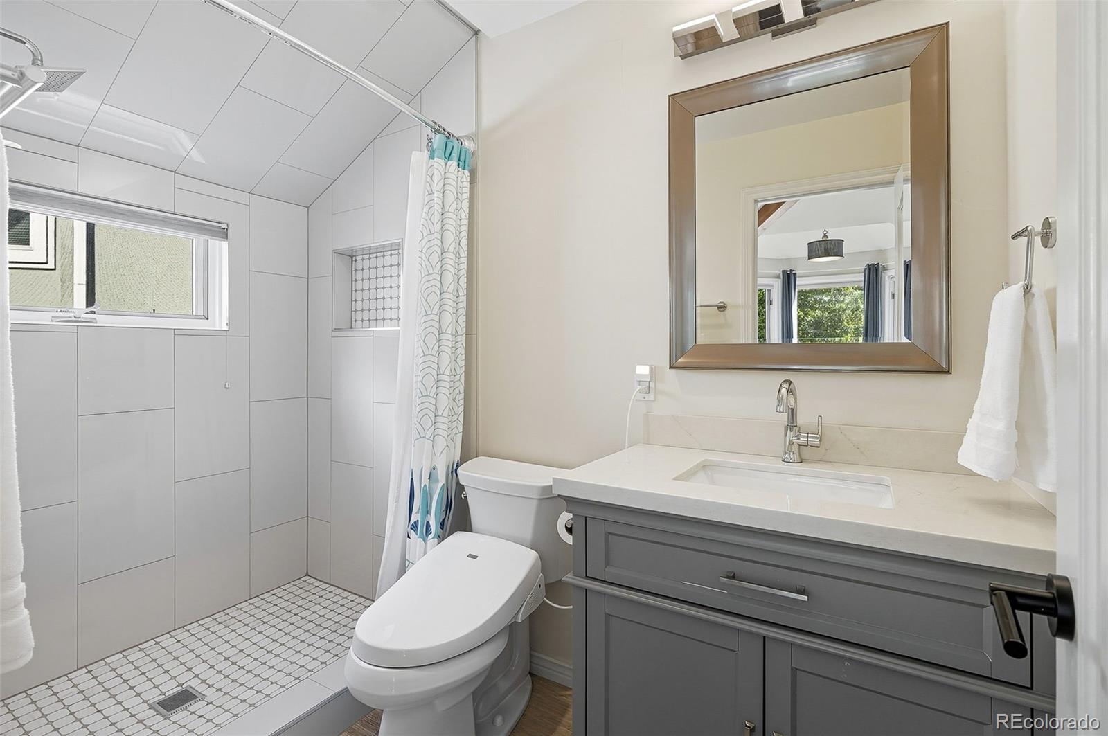 358 Steele Street Denver, CO 80206 - Photo 34 of 48 a bathroom with a sink a toilet and a mirror