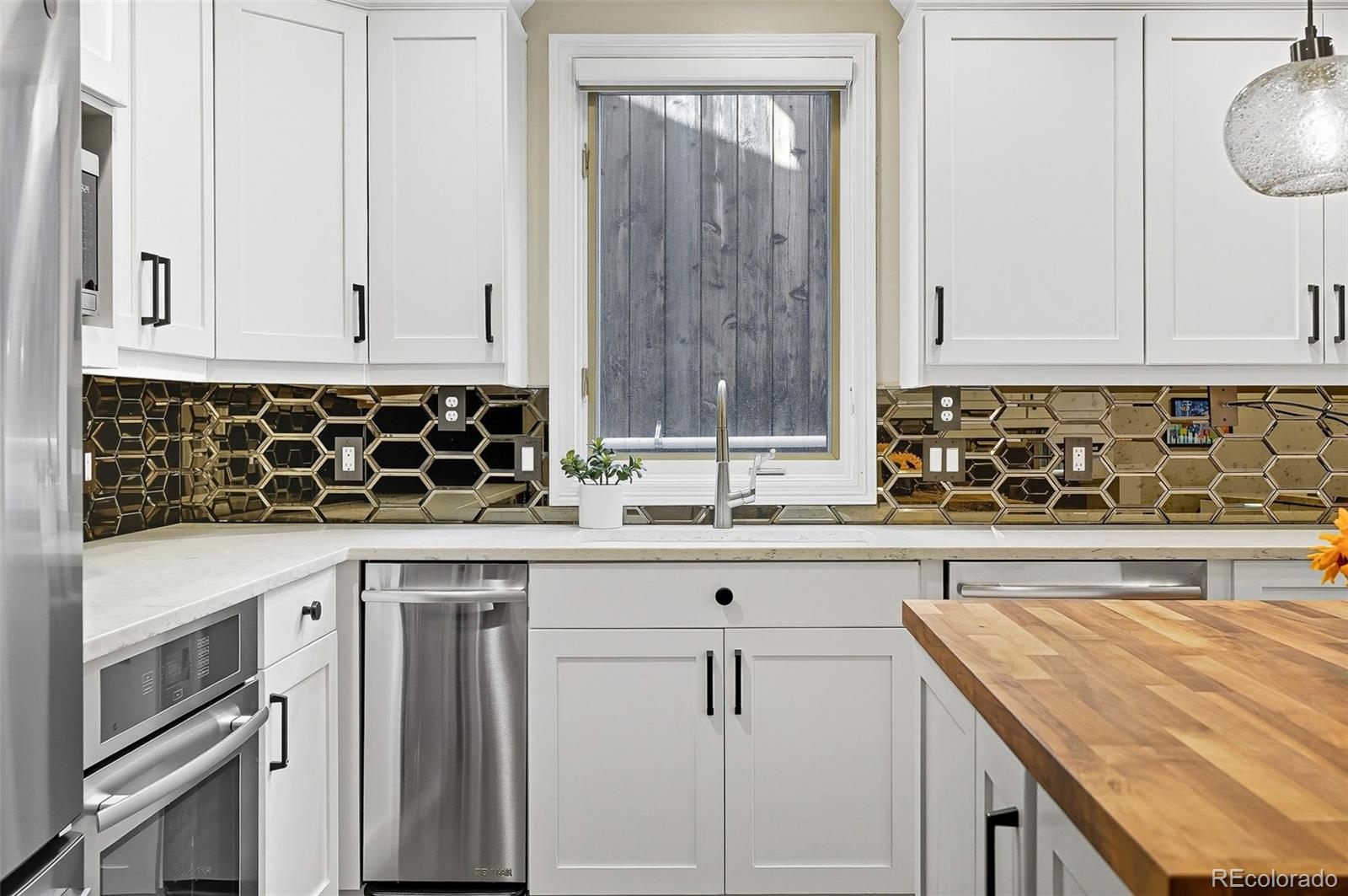 358 Steele Street Denver, CO 80206 - Photo 7 of 48 a kitchen with granite countertop a sink a stove and cabinets