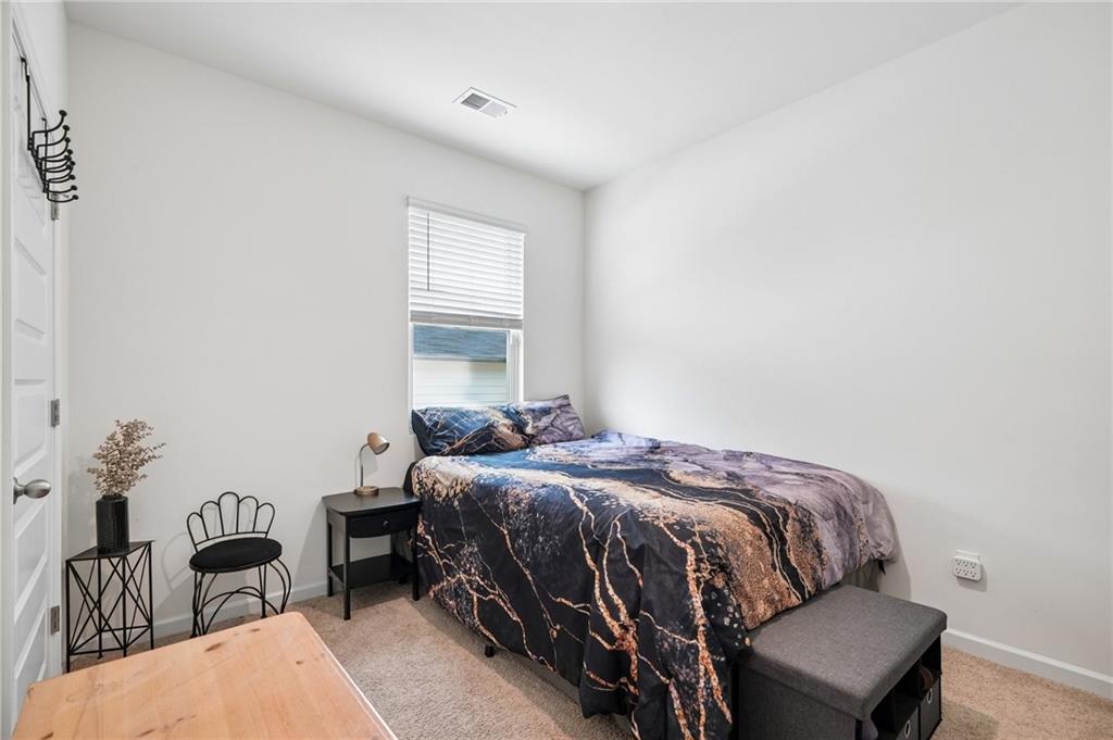 8592 Seabiscuit Road Lithonia, GA 30058 - Photo 13 of 25 a bedroom with a bed and a chair