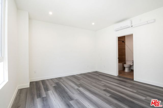 an empty room with wooden floor and closet