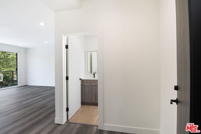 an empty room with wooden floor cabinet and windows