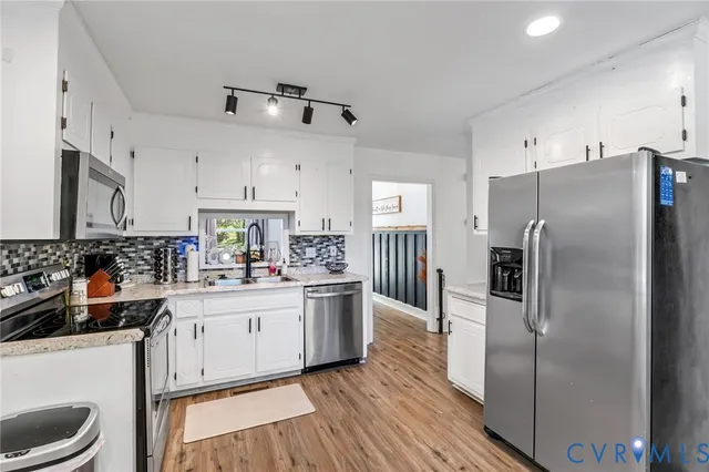 a kitchen with stainless steel appliances a stove refrigerator sink and cabinets