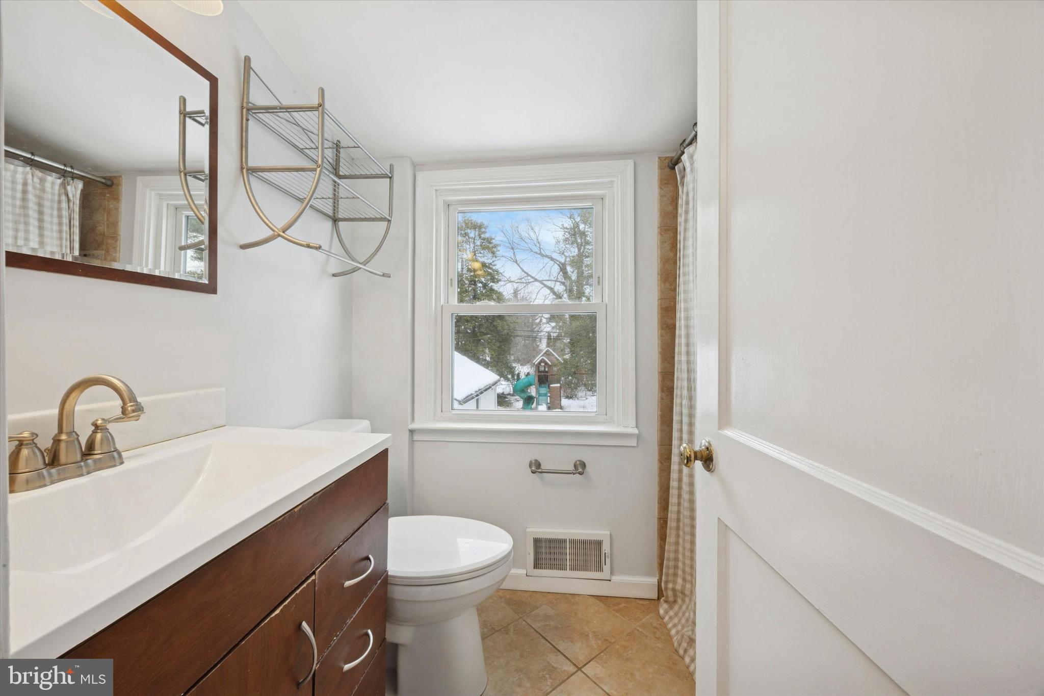 933 Greenbriar Lane Springfield, PA 19064 - Photo 12 of 20 a bathroom with a sink a toilet and a window