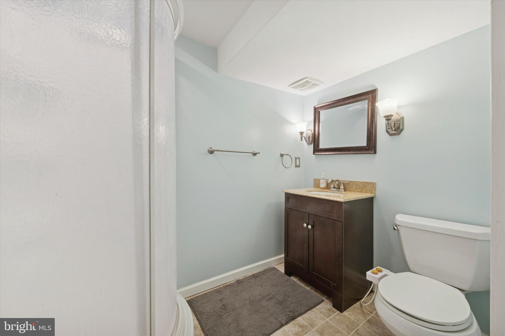 933 Greenbriar Lane Springfield, PA 19064 - Photo 14 of 20 a bathroom with a toilet sink vanity and mirror