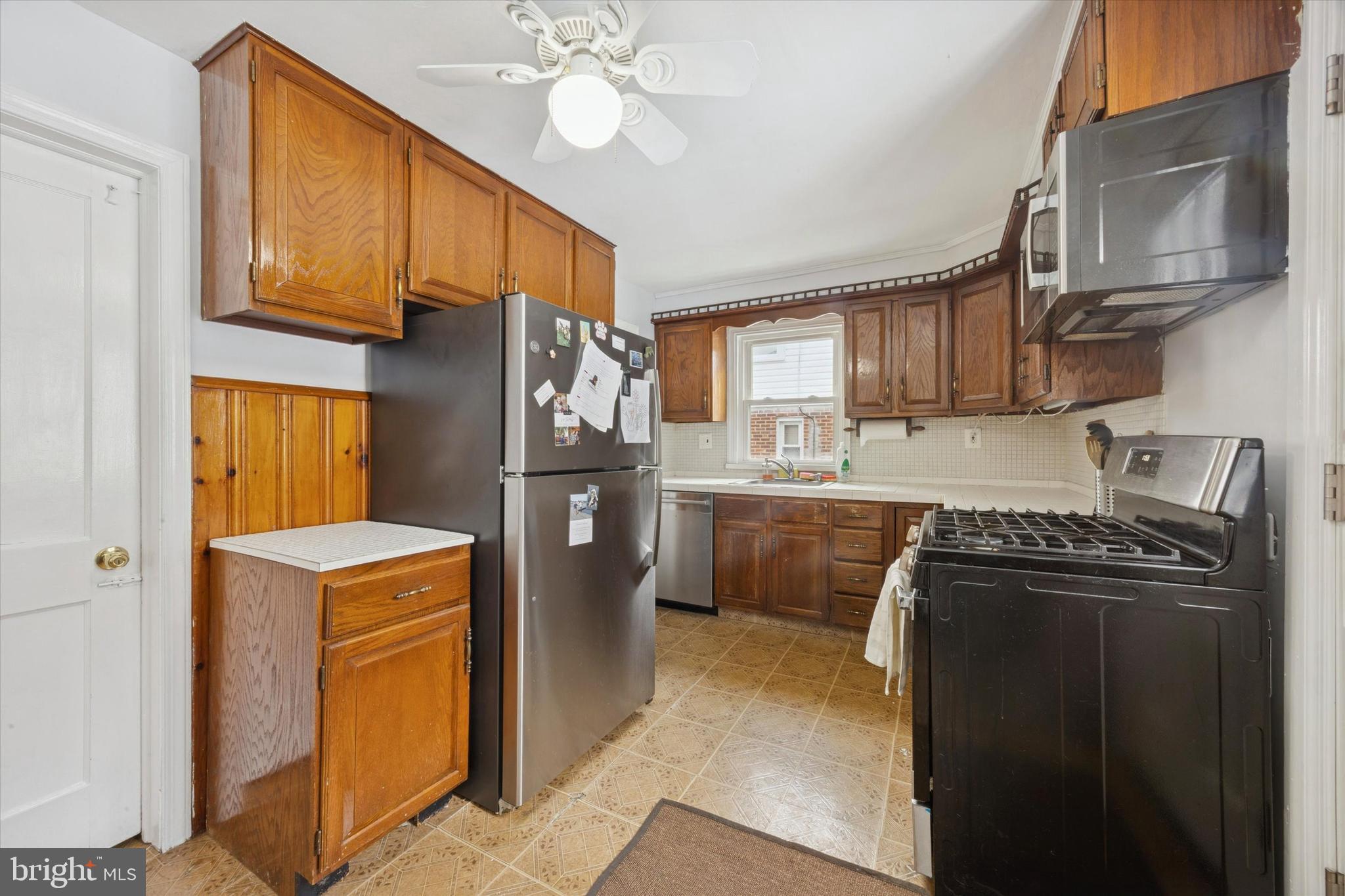 933 Greenbriar Lane Springfield, PA 19064 - Photo 6 of 20 a kitchen with a refrigerator sink and cabinets
