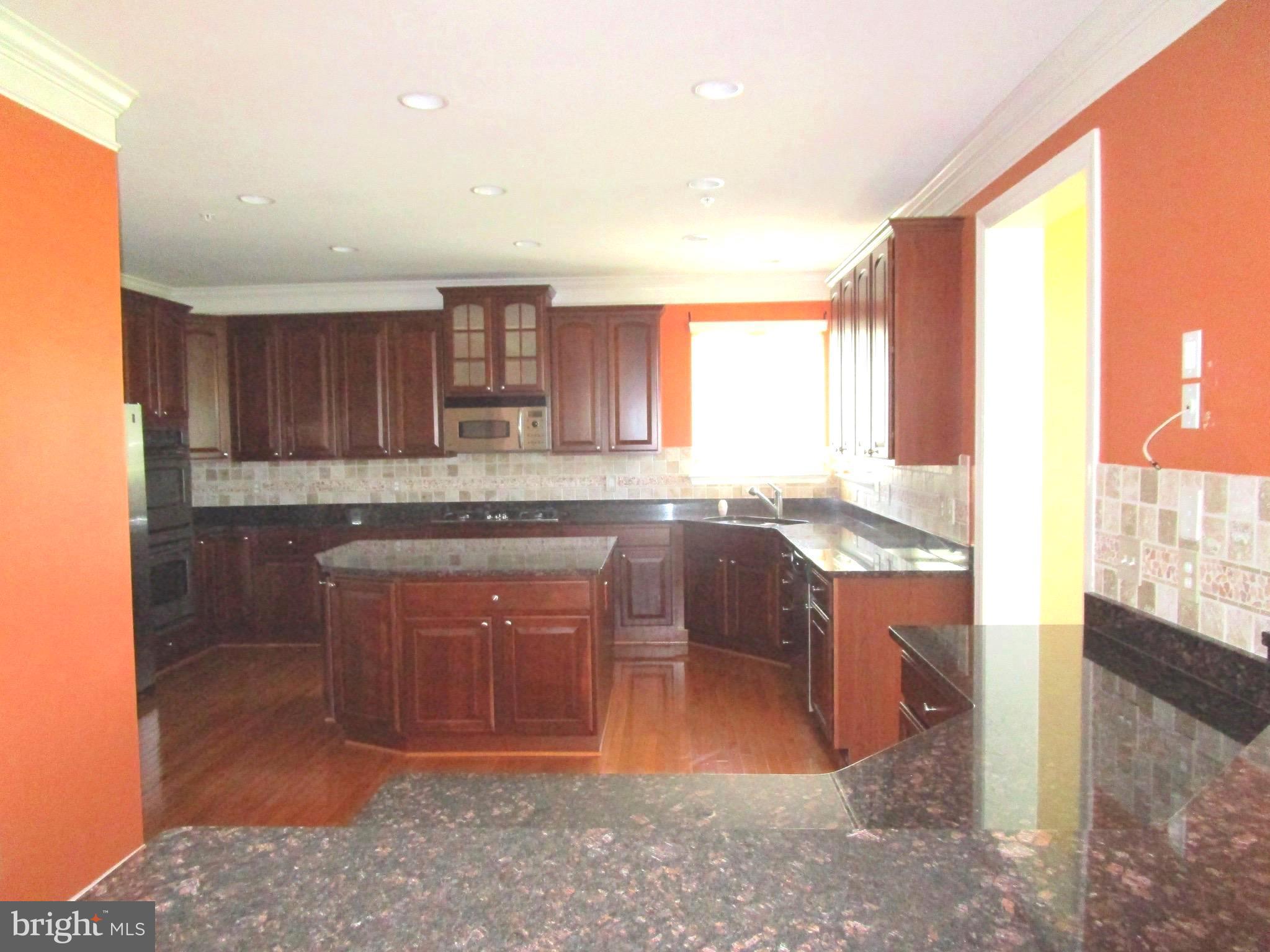 14204 Derby Ridge Road Bowie, MD 20721 - Photo 4 of 27 a kitchen with granite countertop a stove a sink and a microwave