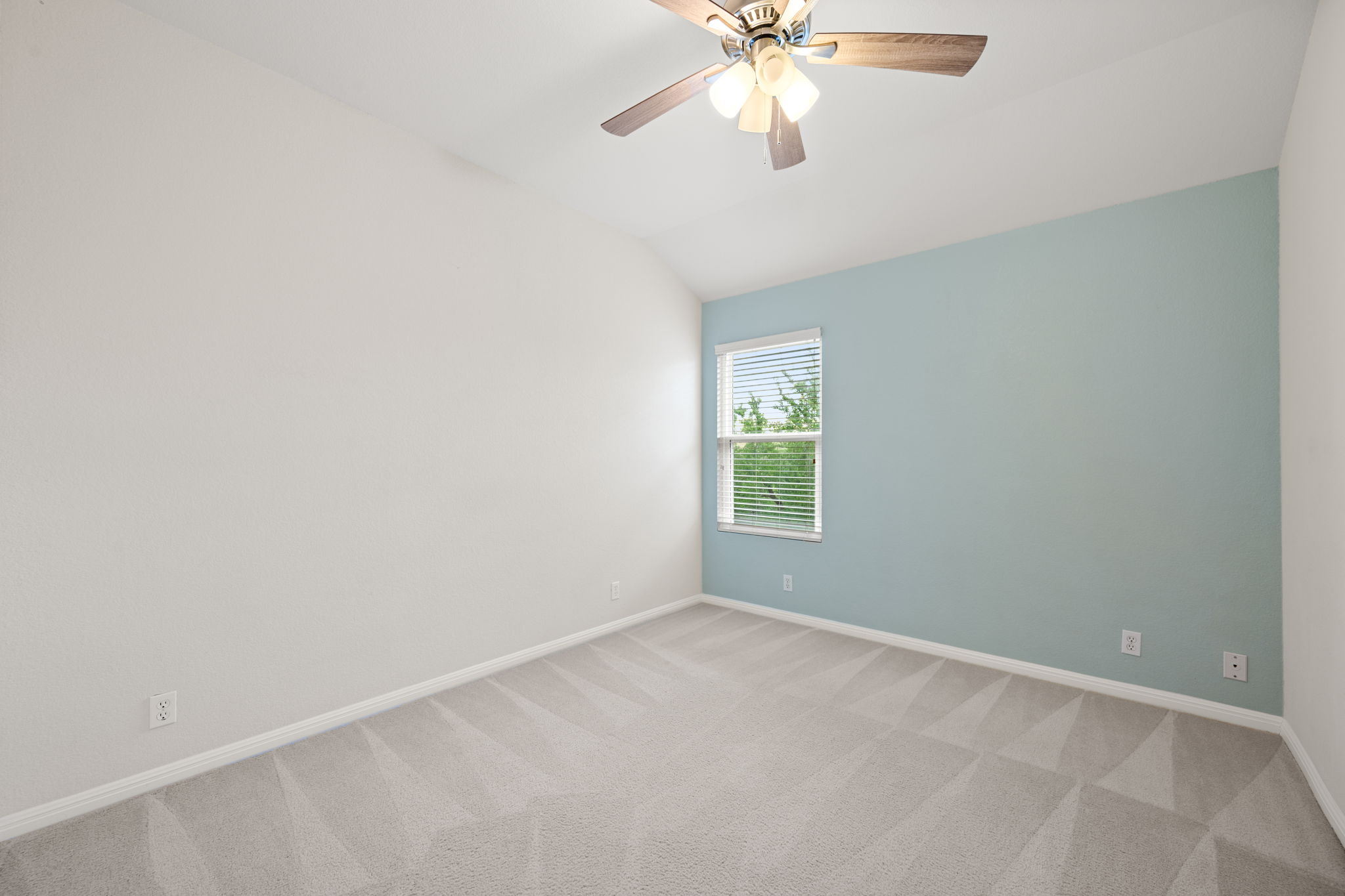 8902 Magna Carta Loop, Unit 122 Austin, TX 78754 - Photo 23 of 39 A well-lit bedroom features plush carpeting and a ceiling fan, offering a comfortable personal retreat.
