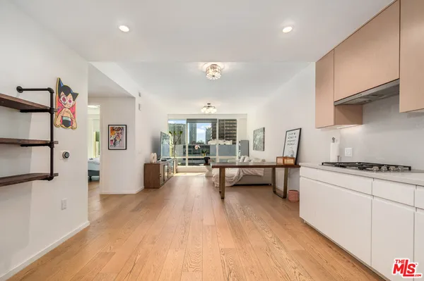 a kitchen with stainless steel appliances a stove a sink dishwasher and a refrigerator with wooden floor
