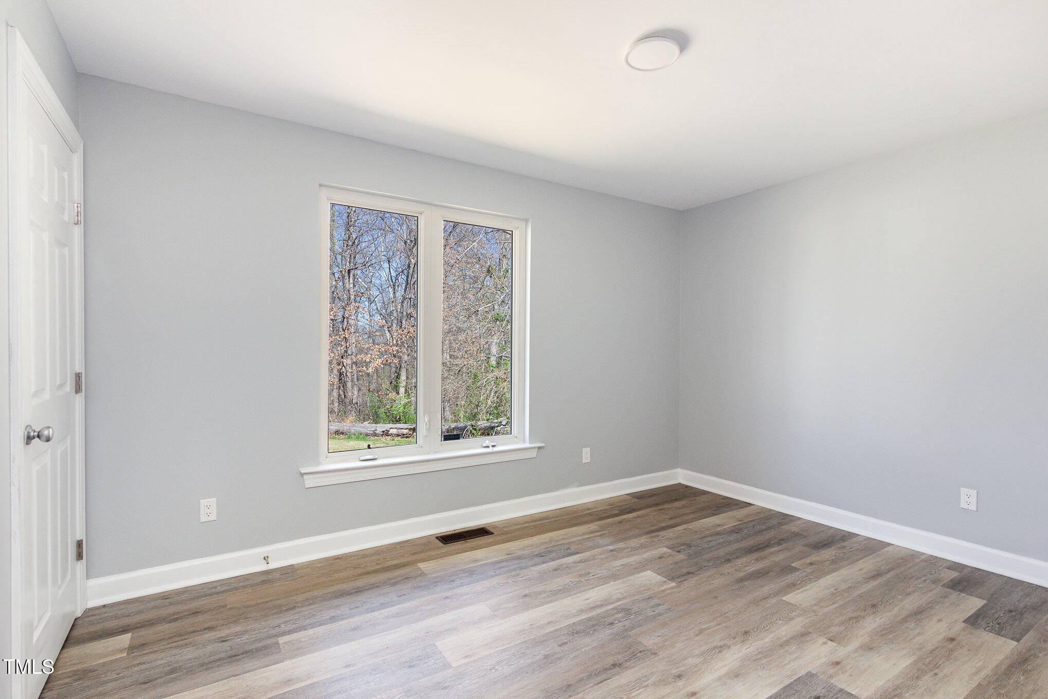 1809 Coltrane Court Raleigh, NC 27610 - Photo 10 of 13 an empty room with wooden floor and windows