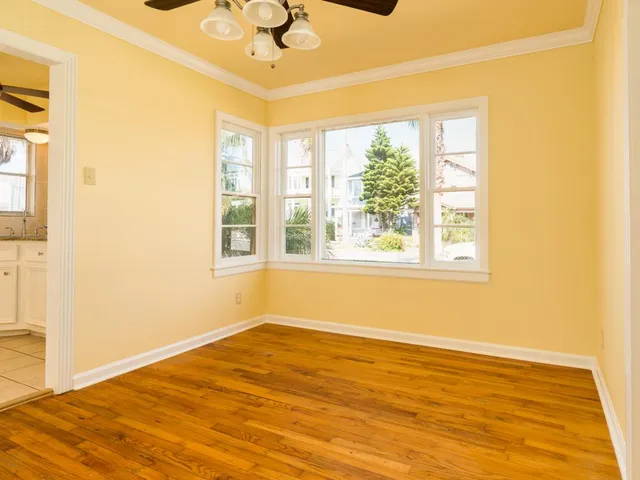 a view of an empty room with a window and a ceiling fan