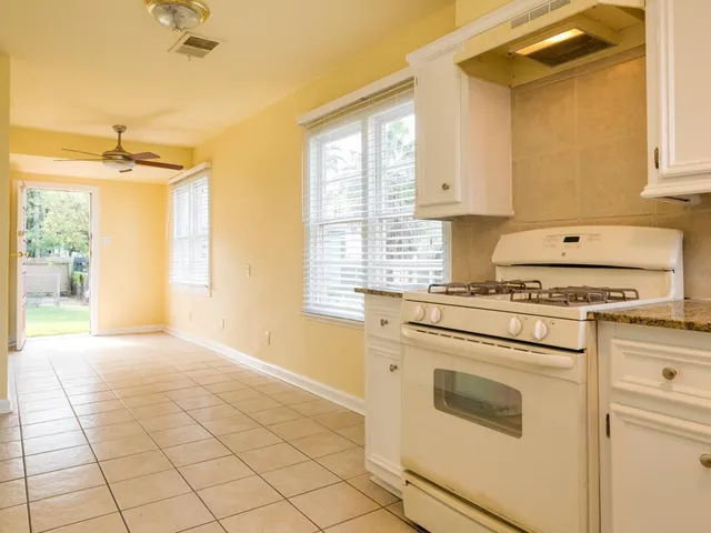 a kitchen with a stove a sink and a window