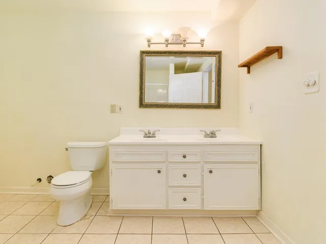 a bathroom with a toilet sink and mirror