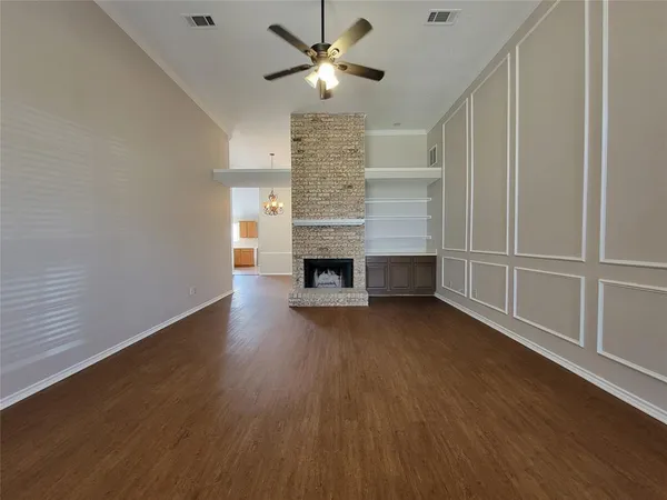 a view of empty room with wooden floor and fireplace