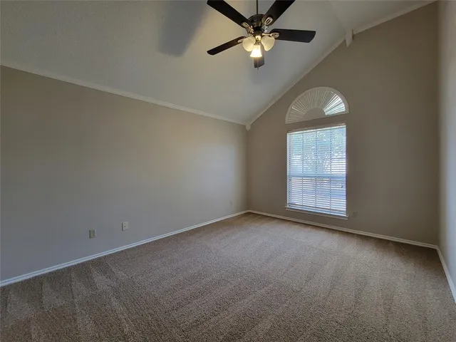 an empty room with windows and chandelier fan