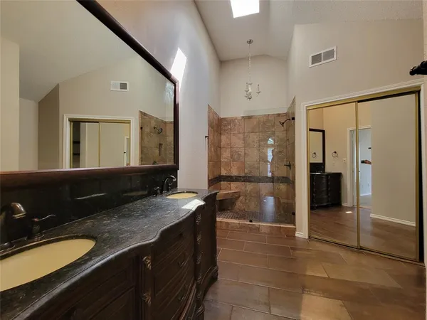 a bathroom with a granite countertop sink shower and a mirror