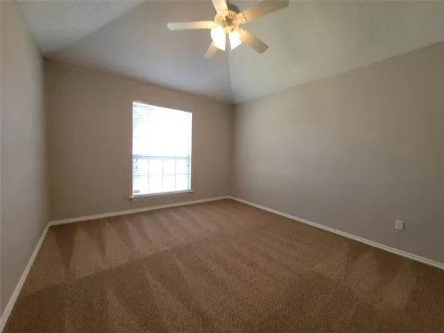 an empty room with a window and a fan