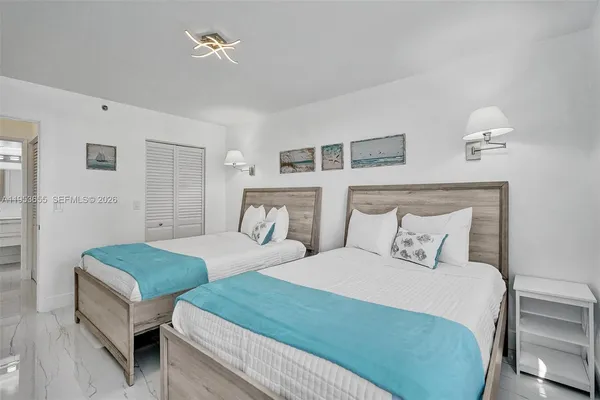 a bedroom with two beds and painting on the wall