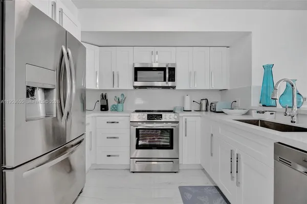 a kitchen with white cabinets and stainless steel appliances