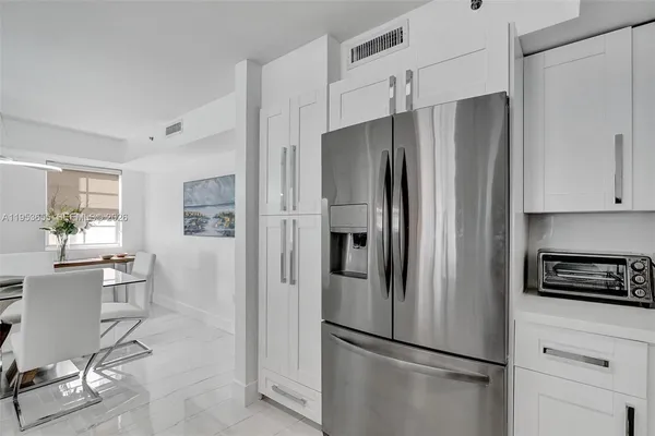 a metallic refrigerator freezer sitting in a kitchen