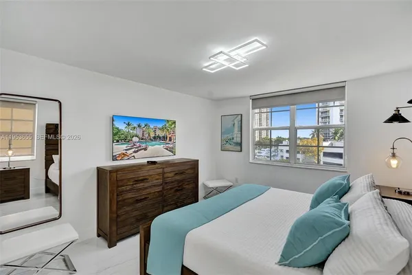 a bedroom with a bed and a chandelier