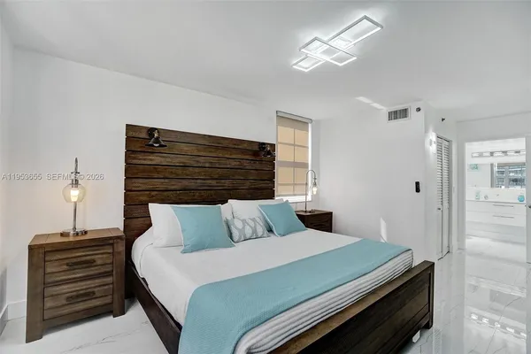 a bedroom with furniture and a painting on the wall