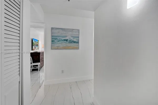 a view of a hallway with wooden floor and a workspace