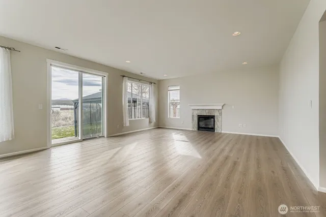 wooden floor fireplace and windows in an empty room
