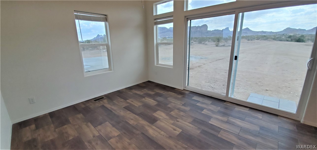 1434 Dilcon Road Golden Valley, AZ 86413 - Photo 12 of 49 an empty room with wooden floor and windows