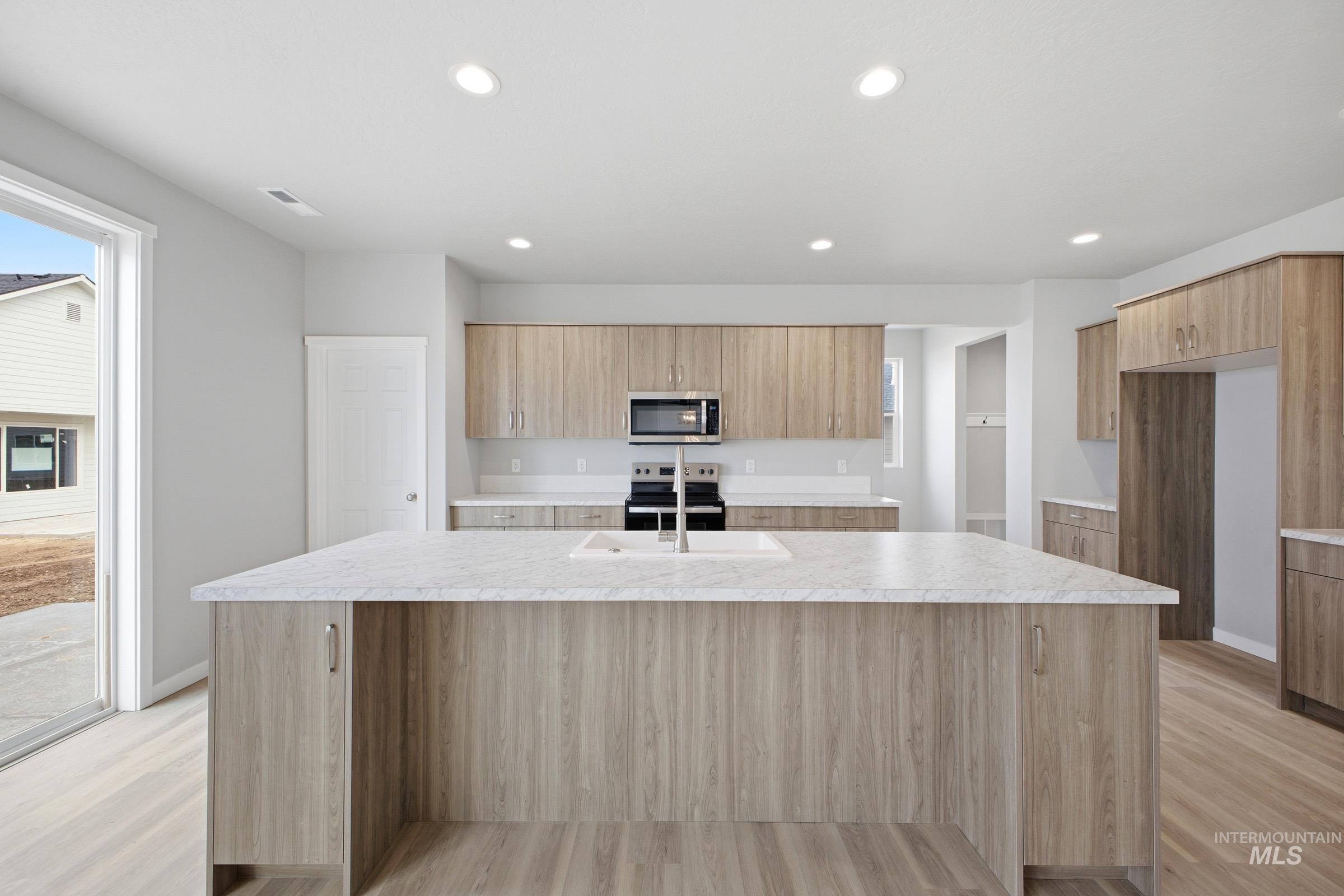 13672 Redway Court Caldwell, ID 83607 - Photo 3 of 34 Kitchen featuring a kitchen island with sink, stainless steel appliances, recessed lighting, light wood finished floors, and modern cabinets