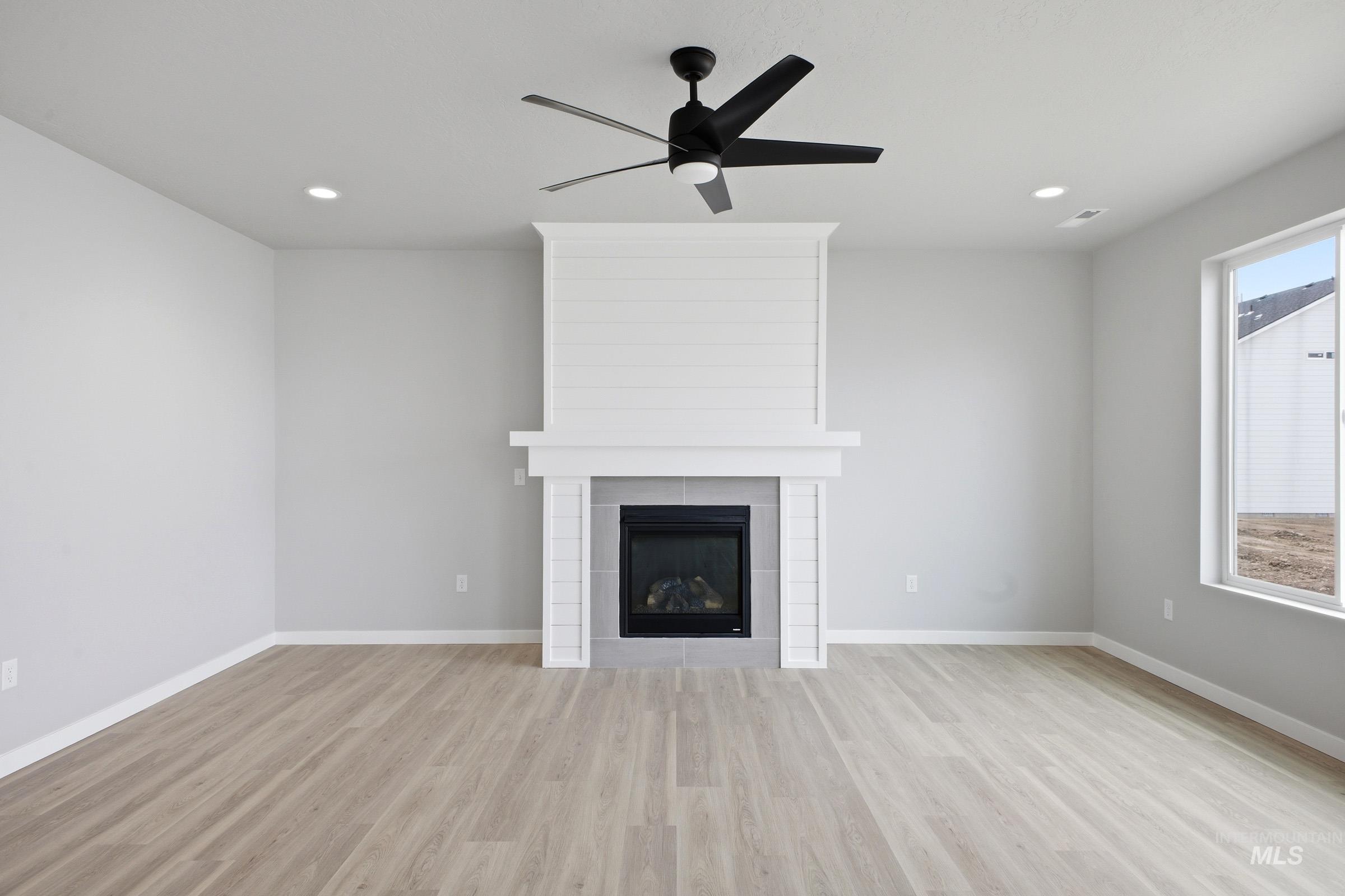 13672 Redway Court Caldwell, ID 83607 - Photo 8 of 34 Unfurnished living room with light wood finished floors, a fireplace, ceiling fan, and recessed lighting