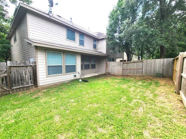 a view of a house with wooden fence and a large tree