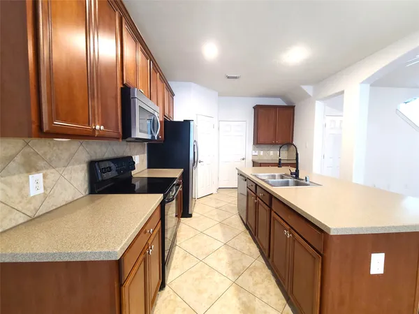 a large kitchen with stainless steel appliances granite countertop a stove a sink dishwasher and a refrigerator