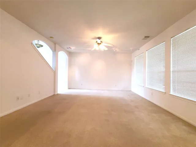 a view of a room with a ceiling fan and window