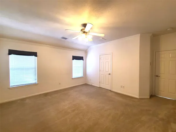 a view of a big room with windows and chandelier fan
