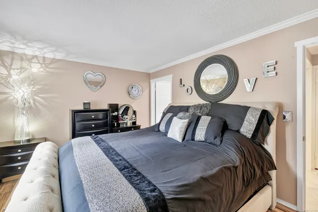 a bed room with a bed and painting on the wall