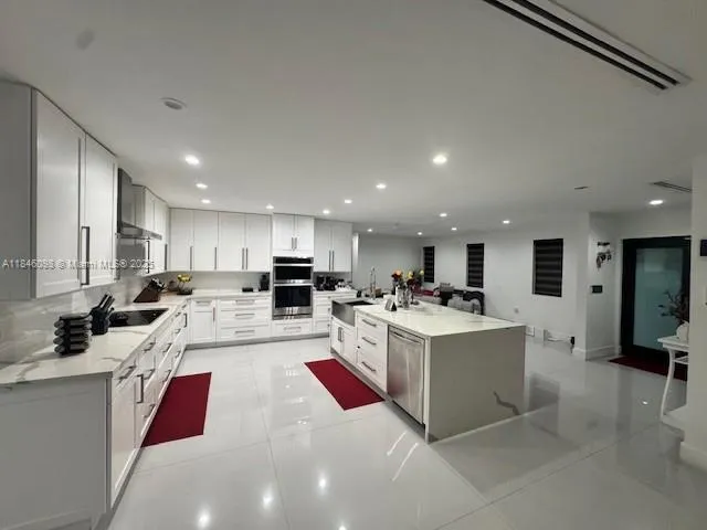 a view of kitchen with stainless steel appliances kitchen island sink stove and refrigerator