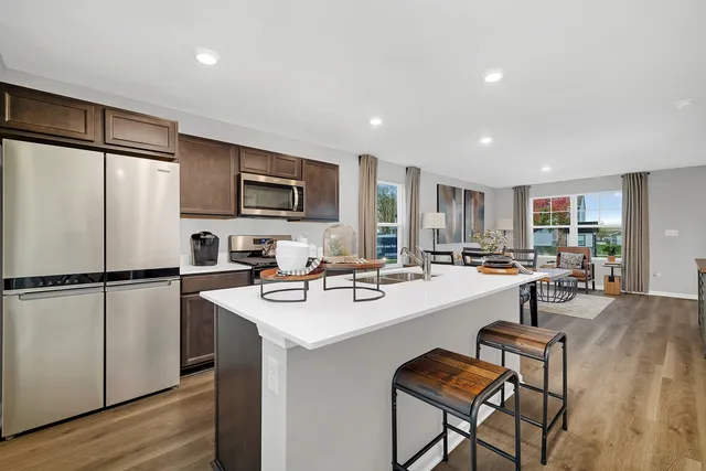 a kitchen with refrigerator and chairs
