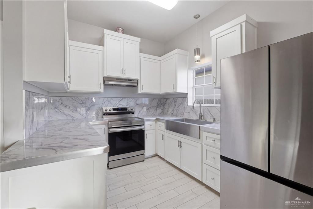 804 Hawk Street Alamo, TX 78516 - Photo 3 of 14 a kitchen with stainless steel appliances white cabinets and a refrigerator