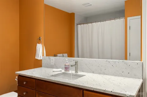 a bathroom with a granite countertop sink and a mirror