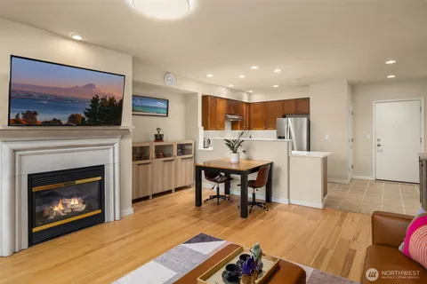 a living room with furniture a fireplace and kitchen view