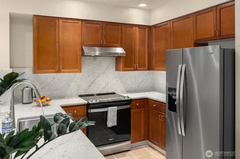 a kitchen with stainless steel appliances granite countertop a refrigerator and a sink