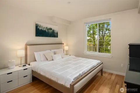 a bedroom with a bed and a flat tv screen on a dresser