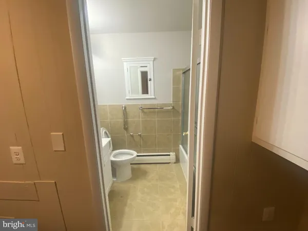 a bathroom with a granite countertop toilet and a sink