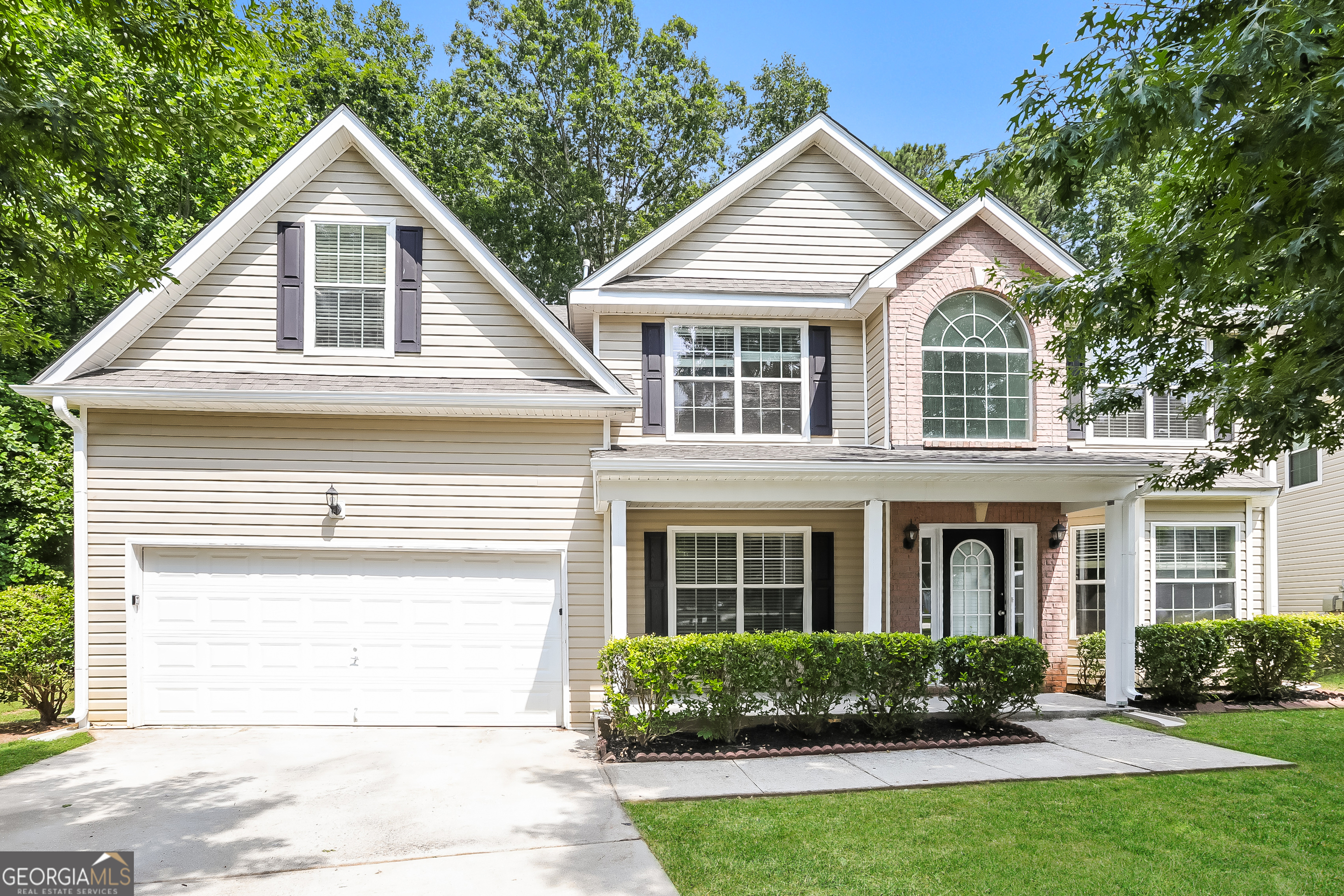 a front view of a house with a yard and potted plants