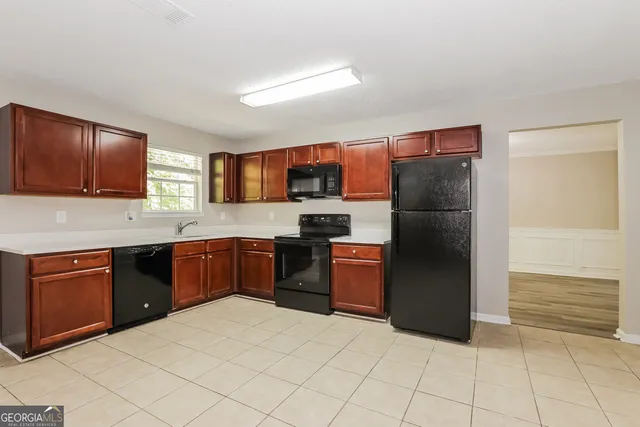 a kitchen with stainless steel appliances granite countertop a refrigerator and a stove top oven